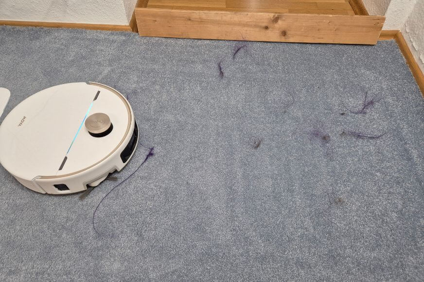 Der MOVA V70 Ultra Complete beim Saugtest von Haaren auf dem Teppich.